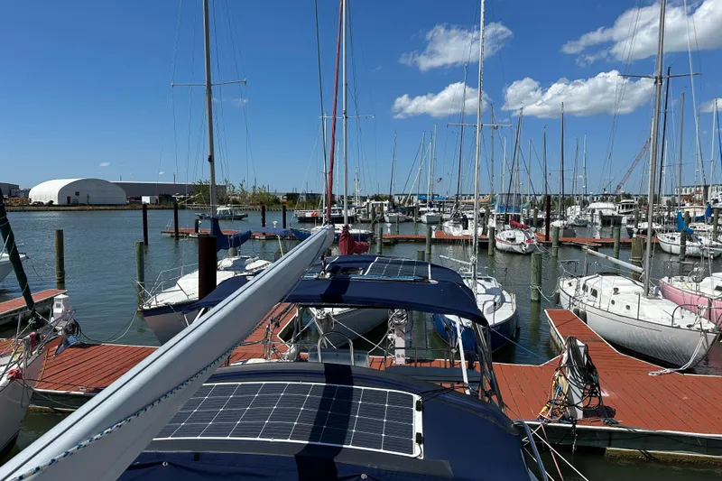 Mischievous Mermaid Yacht Photos Pics Marina view with 2004 Hunter Deck Salon sailboat docked under clear blue sky.