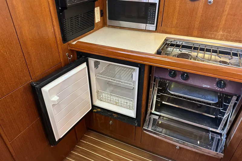 Mischievous Mermaid Yacht Photos Pics 2004 Hunter Deck Salon kitchen with open fridge, oven, and microwave.