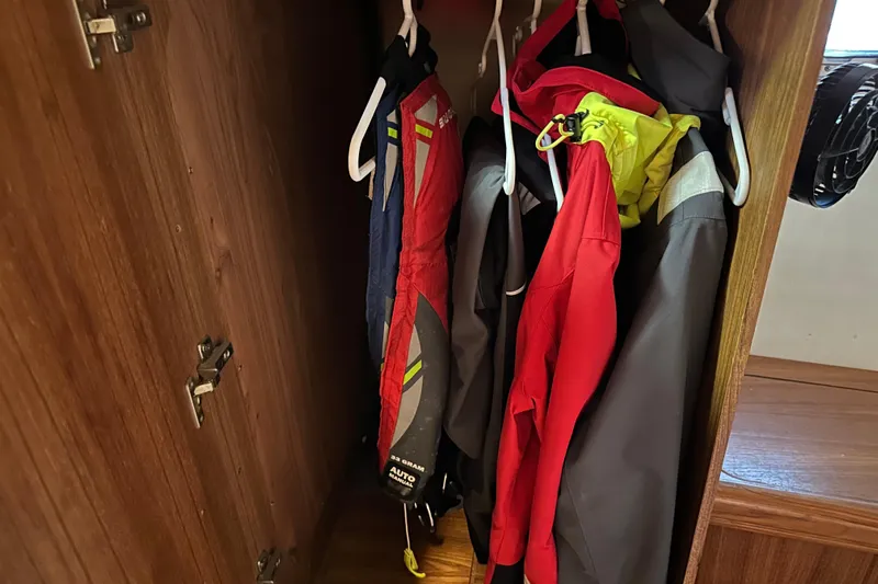 Mischievous Mermaid Yacht Photos Pics Closet with colorful jackets on hangers inside a 2004 Hunter Deck Salon boat.