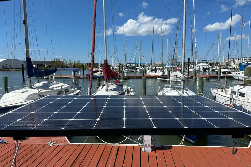 Mischievous Mermaid Yacht Photos Pics Solar panel on dock with Hunter Deck Salon sailboats, marina background, sunny day.