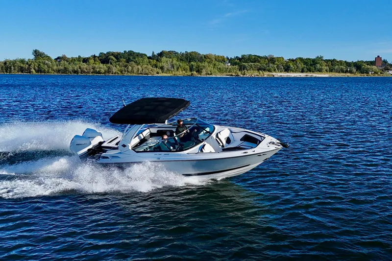  Yacht Photos Pics 2023 Monterey 305SS Super Sport boat cruising on a scenic lake under clear blue skies.