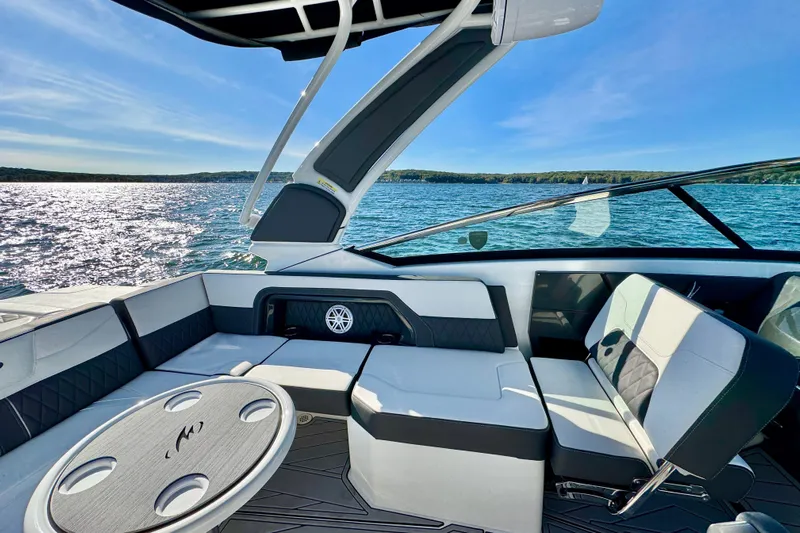  Yacht Photos Pics 2023 Monterey 305SS Super Sport boat interior with seating and table on a sunny lake.