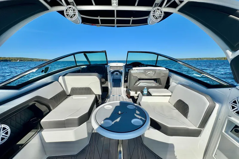 Yacht Photos Pics 2023 Monterey 305SS Super Sport boat interior with seating and table on a sunny day.