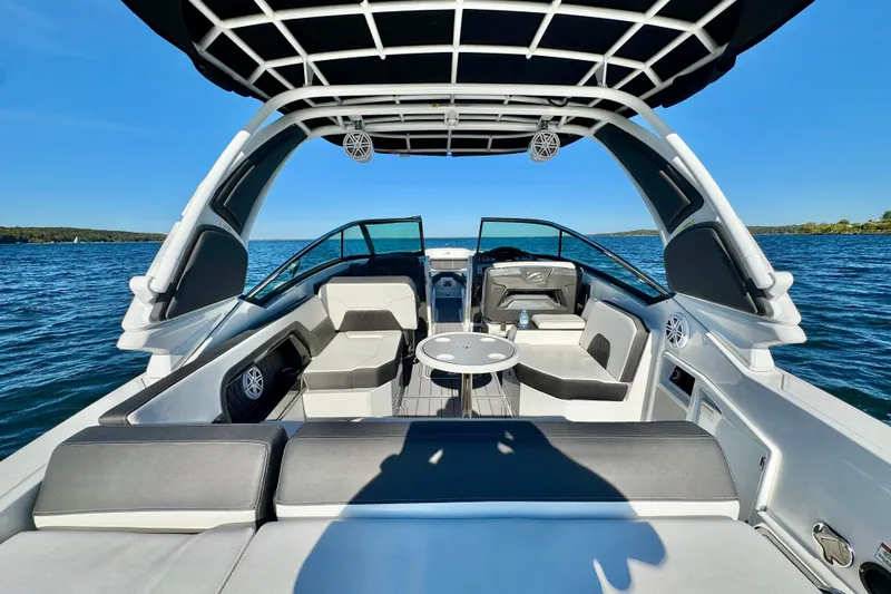  Yacht Photos Pics 2023 Monterey 305SS Super Sport boat interior on a sunny day, featuring sleek seating and table.