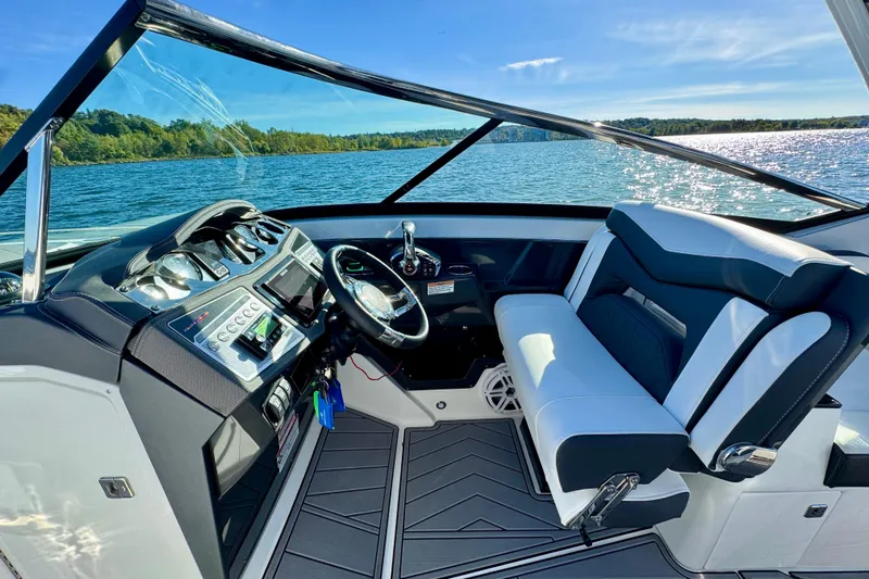  Yacht Photos Pics 2023 Monterey 305SS Super Sport boat interior with sleek dashboard and comfortable seating on a sunny day.