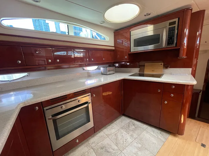  Yacht Photos Pics Luxurious kitchen in 2006 Neptunus 55 Royale yacht with modern appliances and wood cabinetry.