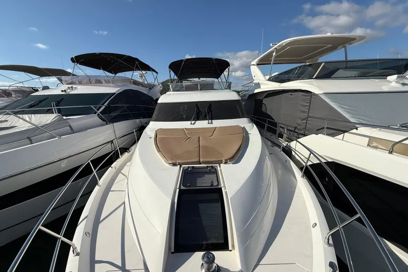 Marckeric Yacht Photos Pics Luxury Fairline Squadron 58 yacht, 2012 model, docked among other boats under clear skies.