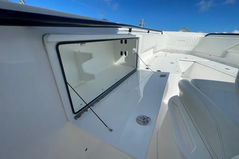  Yacht Photos Pics 2022 Everglades 335 Center Console boat interior storage compartment, open under clear blue sky.