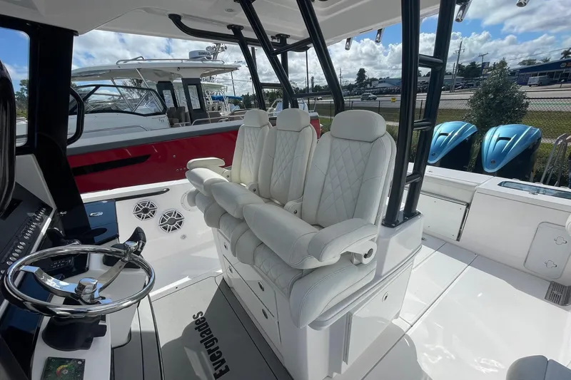  Yacht Photos Pics 2022 Everglades 335 Center Console boat interior with white seating and steering wheel.