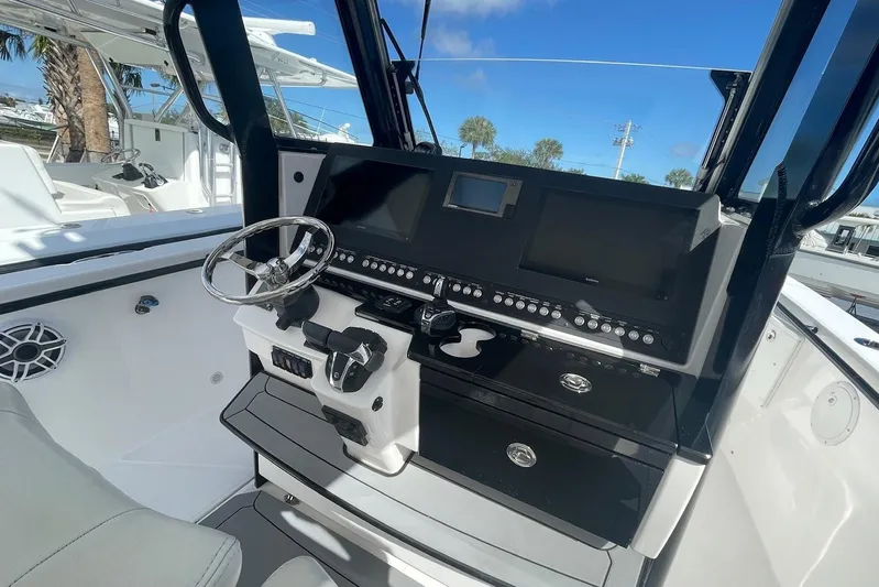  Yacht Photos Pics 2022 Everglades 335 Center Console boat dashboard with steering wheel and control panel.