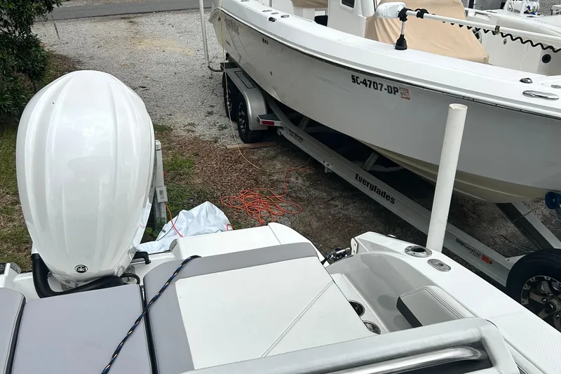  Yacht Photos Pics 2024 Cobalt R6 boat with outboard motor, parked beside another boat on a trailer.