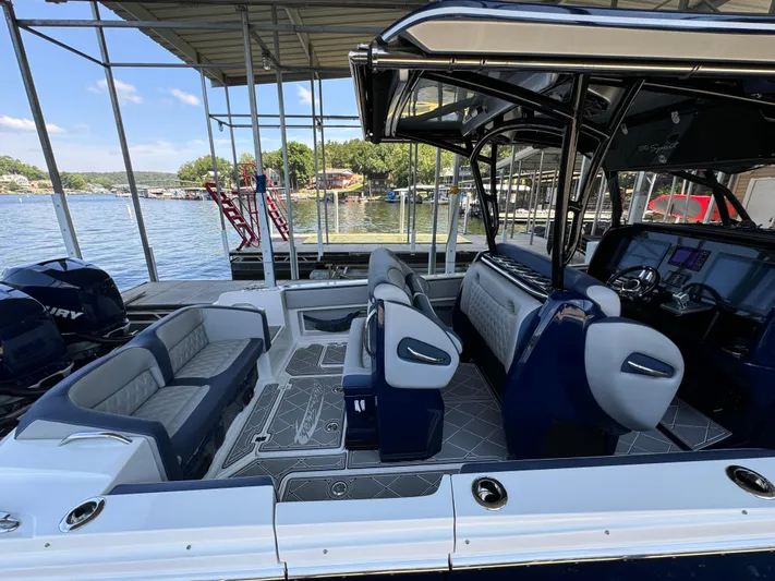 Yacht Photos Pics 2019 Nor-Tech 390 Sport Center Console boat interior with seating and controls, docked by a lake.