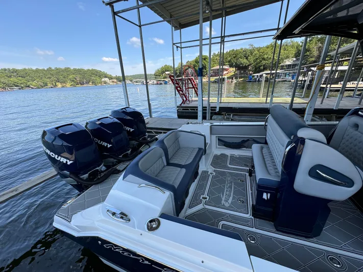  Yacht Photos Pics 2019 Nor-Tech 390 Sport Center Console boat with triple Mercury engines docked by a lake.