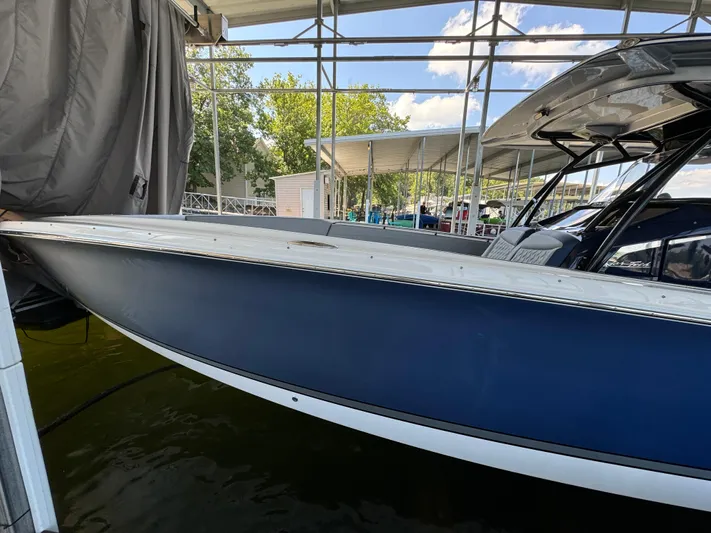  Yacht Photos Pics 2019 Nor-Tech 390 Sport Center Console boat docked under a canopy.