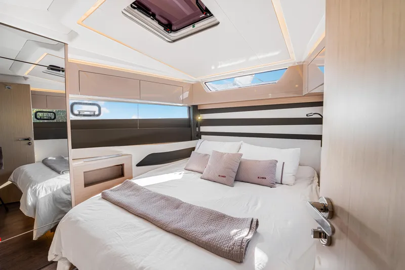 Equanimity Yacht Photos Pics Luxurious interior of 2023 Jeanneau DB43 yacht cabin with modern design and comfortable bedding.