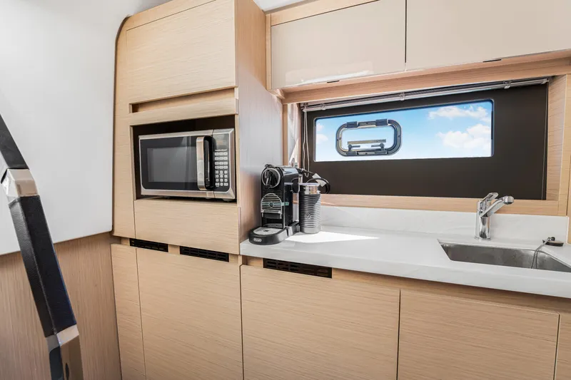 Equanimity Yacht Photos Pics Modern kitchen interior of 2023 Jeanneau DB43 yacht with microwave and coffee maker.