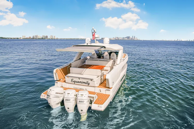 Equanimity Yacht Photos Pics 2023 Jeanneau DB43 yacht cruising on open water with city skyline in background.