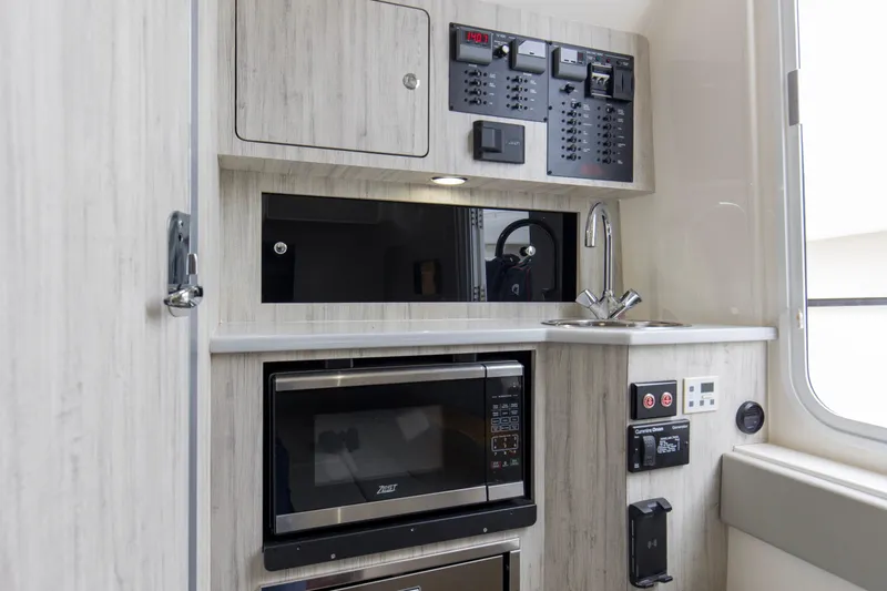  Yacht Photos Pics 2024 Regulator 37 interior with modern kitchenette, microwave, sink, and control panels.