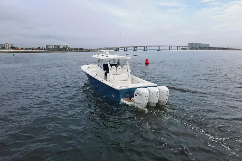  Yacht Photos Pics 2024 Regulator 37 boat cruising on open water near a bridge.
