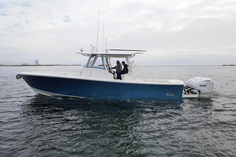  Yacht Photos Pics 2024 Regulator 37 boat on water, featuring sleek blue hull and twin Yamaha engines.