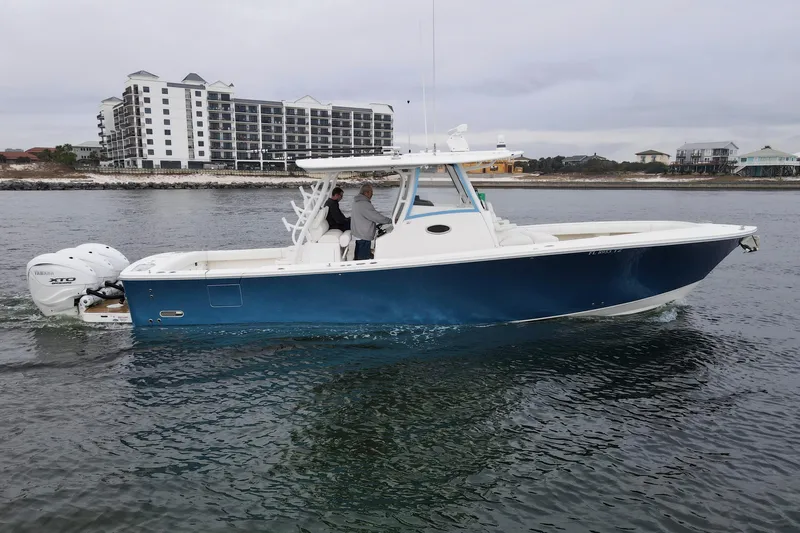  Yacht Photos Pics 2024 Regulator 37 boat cruising on water near coastal buildings.