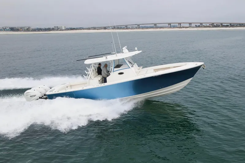  Yacht Photos Pics 2024 Regulator 37 boat cruising on open water with cityscape in background.