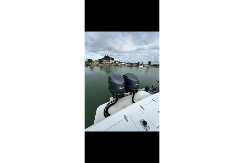  Yacht Photos Pics 2003 Jupiter 31 boat with dual outboard engines on a calm waterfront.