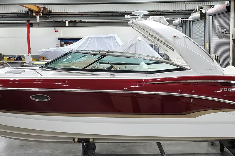  Yacht Photos Pics 2012 Formula 310 Sun Sport boat in a workshop, featuring sleek red and white design.