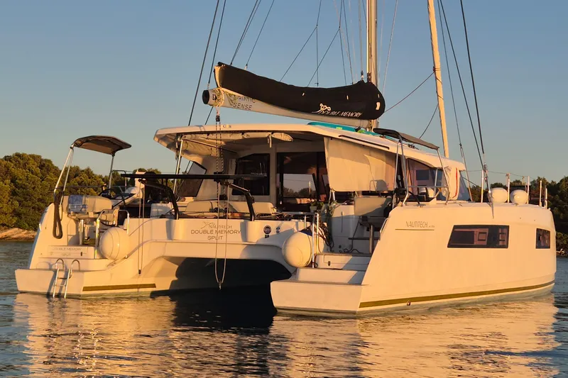 Double Memory Yacht Photos Pics 2023 Nautitech 44 catamaran on calm water at sunset, showcasing sleek design and modern features.