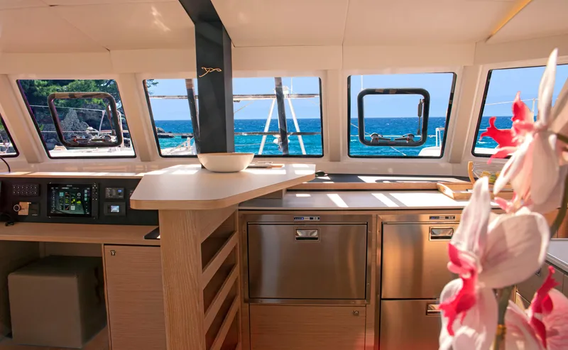 Double Memory Yacht Photos Pics Interior of 2023 Nautitech 44 catamaran with ocean view, modern kitchen, and vibrant flowers.