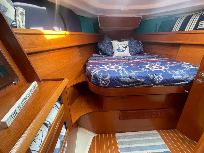 Karisma Yacht Photos Pics Cozy cabin interior of 2006 Jeanneau Sun Odyssey 45 sailboat with nautical-themed bedding.