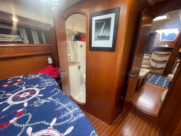 Karisma Yacht Photos Pics Cozy interior of 2006 Jeanneau Sun Odyssey 45 sailboat with nautical-themed bedding.