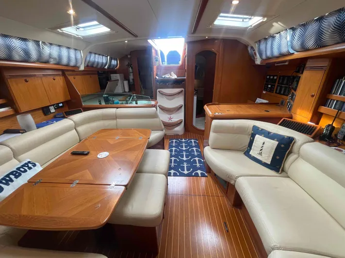 Karisma Yacht Photos Pics Luxurious interior of 2006 Jeanneau Sun Odyssey 45 sailboat with elegant wood finish and cozy seating.
