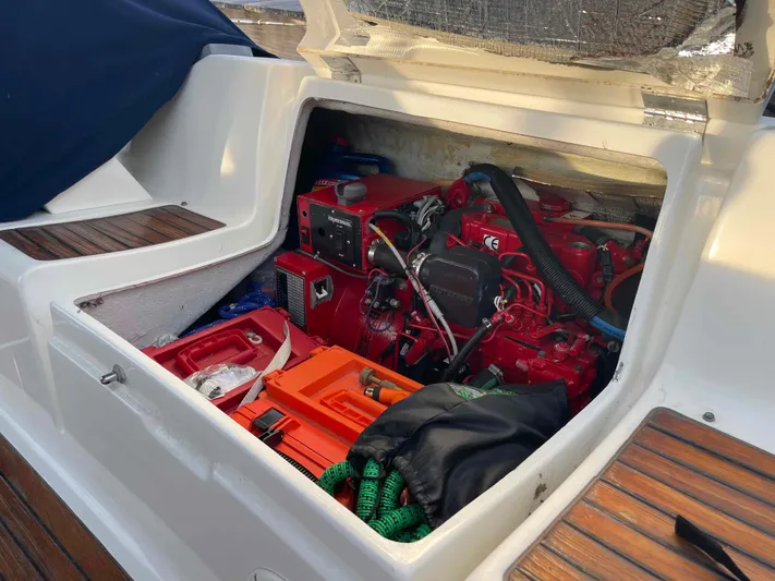 Karisma Yacht Photos Pics Engine compartment of 2006 Jeanneau Sun Odyssey 45 sailboat, showing red engine and storage.