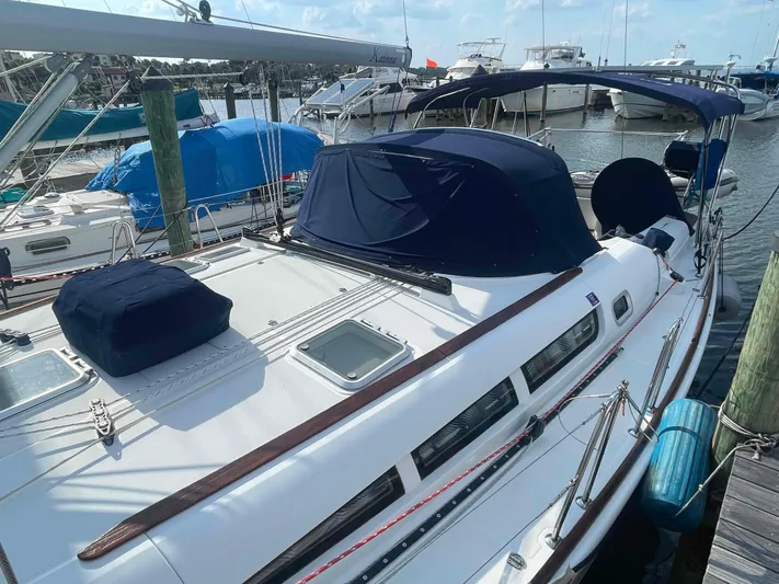 Karisma Yacht Photos Pics 2006 Jeanneau Sun Odyssey 45 sailboat docked at marina, featuring blue covers and sleek design.