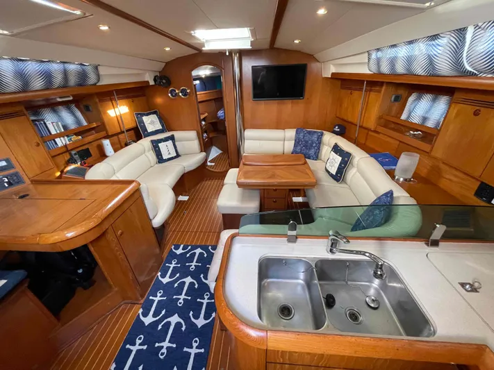 Karisma Yacht Photos Pics Luxurious interior of 2006 Jeanneau Sun Odyssey 45 yacht with elegant wood finish.