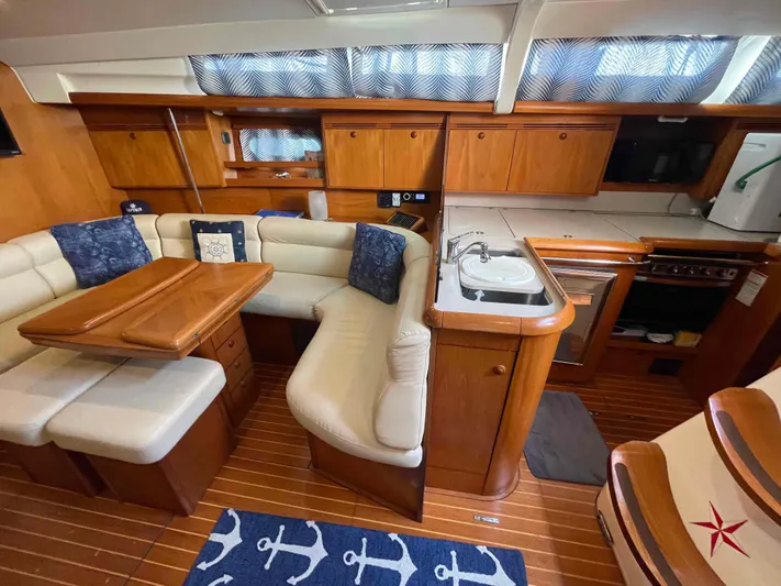 Karisma Yacht Photos Pics Interior of 2006 Jeanneau Sun Odyssey 45 yacht with cozy seating and kitchen area.