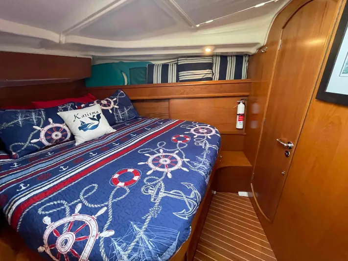 Karisma Yacht Photos Pics Cozy cabin interior of 2006 Jeanneau Sun Odyssey 45 with nautical-themed bedding.
