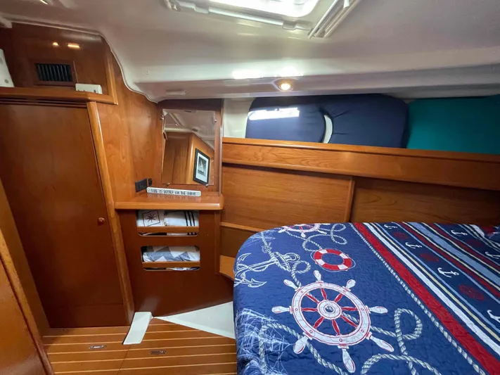 Karisma Yacht Photos Pics Cozy cabin interior of 2006 Jeanneau Sun Odyssey 45 with nautical-themed bedding.