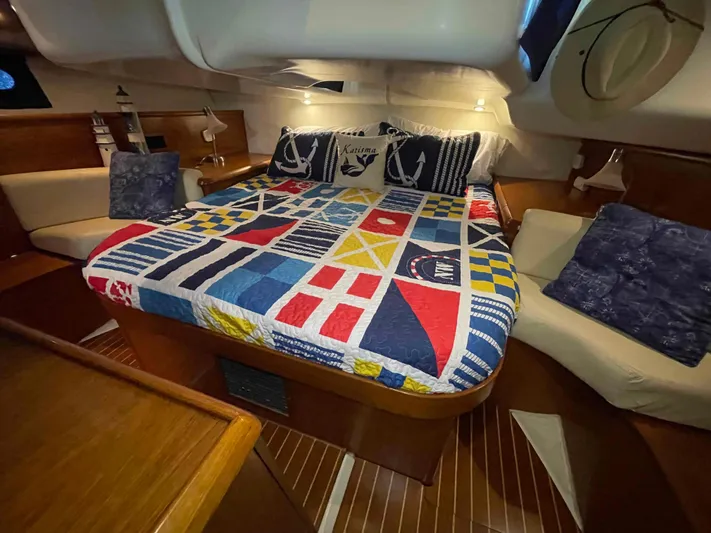Karisma Yacht Photos Pics Cozy cabin interior of 2006 Jeanneau Sun Odyssey 45 with nautical-themed bedding.