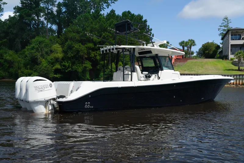  Yacht Photos Pics 2018 HCB 39 Speciale boat on calm water, surrounded by lush greenery.