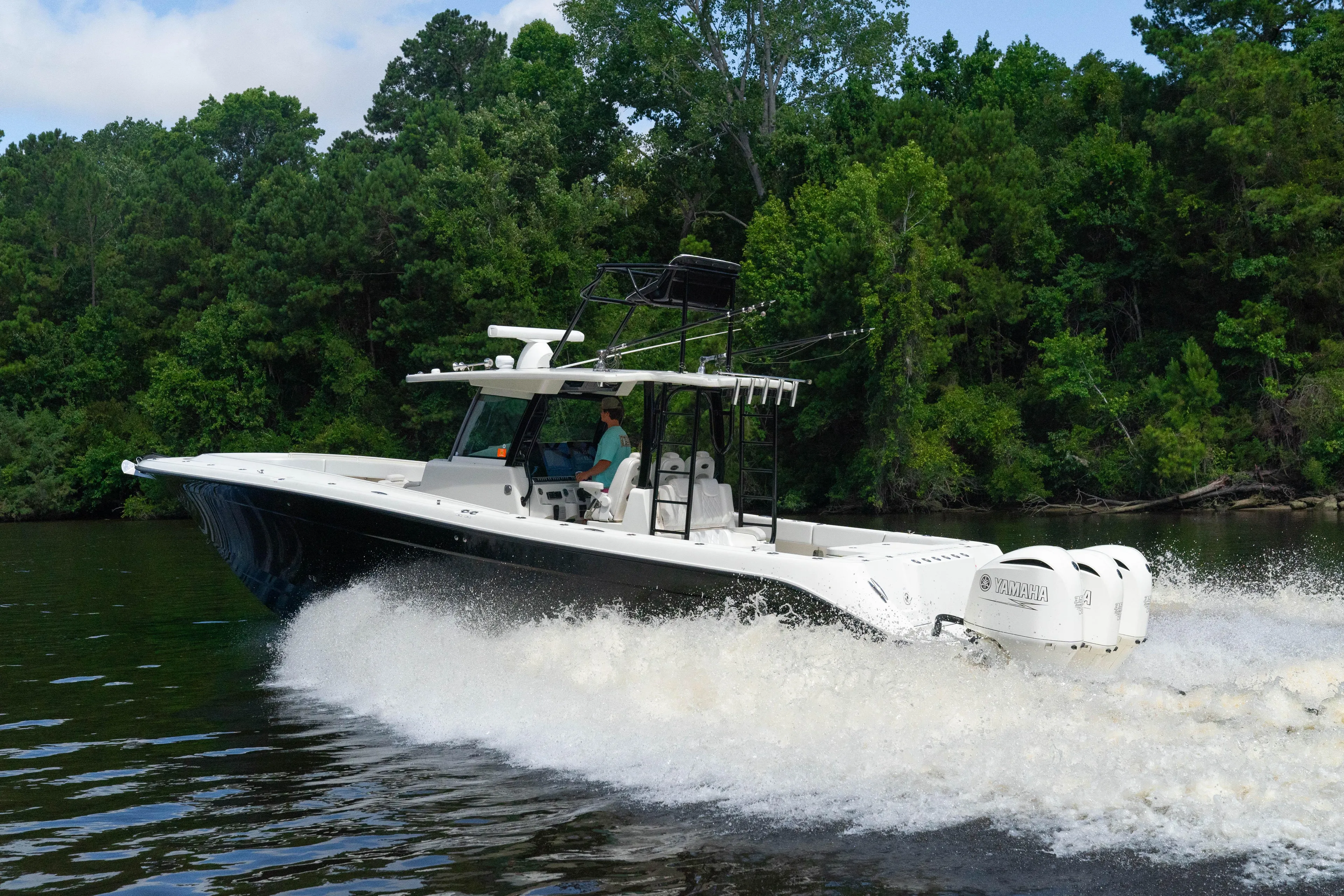  Yacht Photos Pics 2018 HCB 39 Speciale boat cruising on a river with lush green trees.