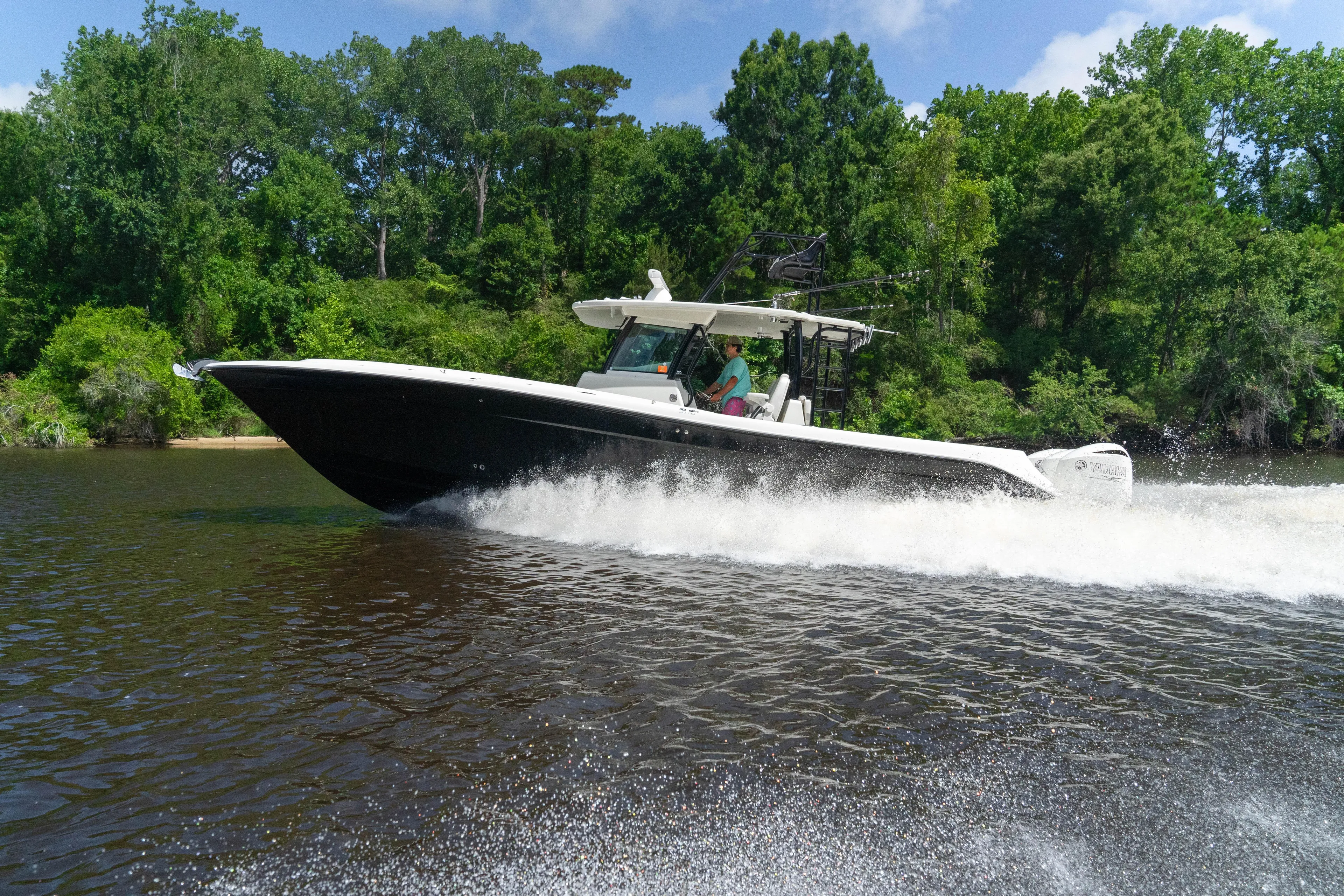  Yacht Photos Pics 2018 HCB 39 Speciale boat cruising on a river with lush green trees.