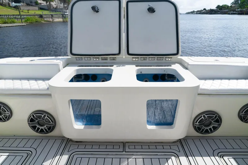  Yacht Photos Pics 2018 HCB 39 Speciale boat with open storage compartments and speakers, docked by the water.
