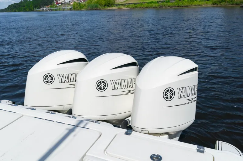  Yacht Photos Pics Triple Yamaha outboard engines on 2018 HCB 39 Speciale boat, cruising on a serene lake.