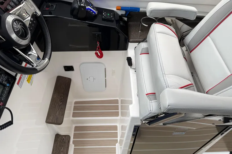  Yacht Photos Pics 2024 Solara S-250 Coupe interior with steering wheel, control panel, and cushioned seat.