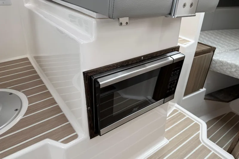  Yacht Photos Pics 2024 Solara S-250 Coupe interior with built-in microwave and stylish wood flooring.