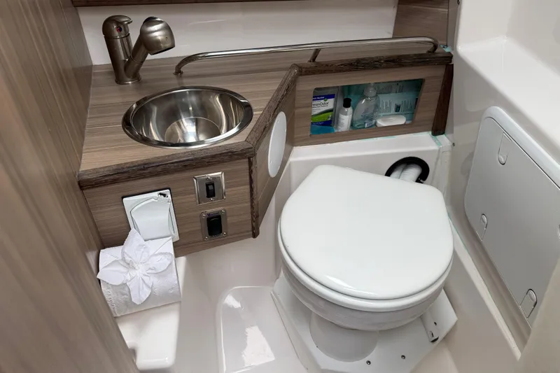  Yacht Photos Pics 2024 Solara S-250 Coupe bathroom with compact sink, toilet, and storage.