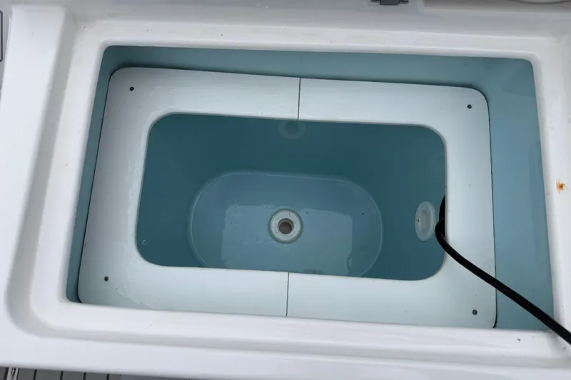  Yacht Photos Pics Livewell compartment in 2024 Solara S-250 Coupe boat, featuring a clean, white interior.