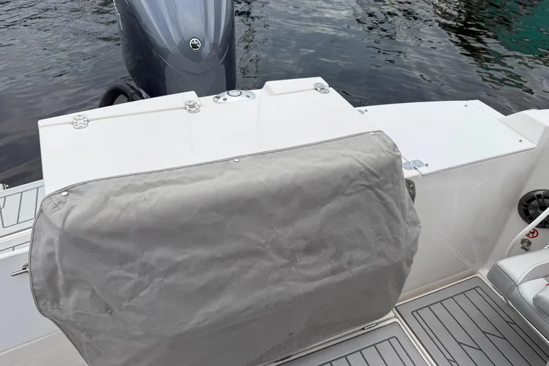  Yacht Photos Pics 2024 Solara S-250 Coupe boat stern with covered engine, docked on calm water.